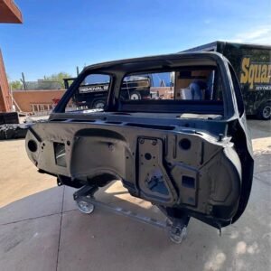 truck cab shell, resembling a 1973–1987 Chevrolet or GMC "squarebody" pickup truck cab mounted on a rolling dolly. [1]